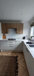 a kitchen with white counters and wooden cabinets at Modern Town House in Mid Wales in Knighton