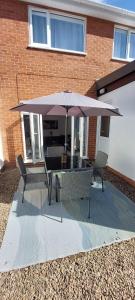 a table with an umbrella in front of a brick building at Modern Town House in Mid Wales in Knighton