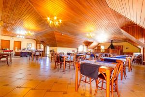 a dining room with wooden tables and chairs at Pousada Alemã in Santo Antônio do Pinhal