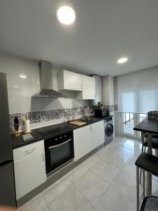 a kitchen with white cabinets and a stove top oven at Piso Sardinero - Almar d'Pipe in Santander