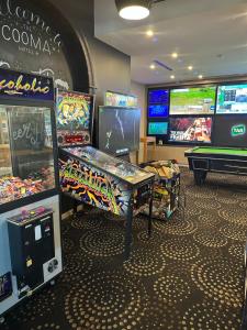 una habitación con juegos de arcade y mesa de billar en Cooma Hotel, en Cooma