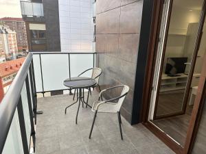 una mesa y sillas en el balcón de un edificio en Piso Sardinero - Almar d'Pipe, en Santander