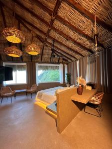 - une chambre avec un lit, une table et des chaises dans l'établissement Quinta Bella Huatulco, à Santa Cruz Huatulco