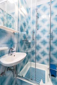 a blue tiled bathroom with a sink and a shower at Apartments with a parking space Crikvenica - 5494 in Crikvenica