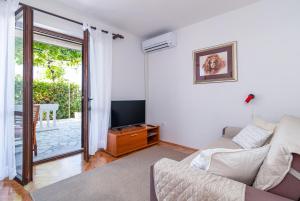 a living room with a couch and a tv at Apartments with a parking space Crikvenica - 5494 in Crikvenica