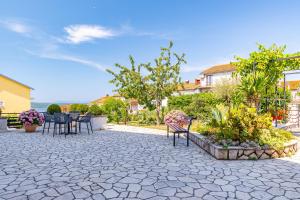 a patio with chairs and a table and plants at Apartment Crikvenica 5494c in Crikvenica