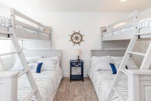 een slaapkamer met 2 stapelbedden en een klok aan de muur bij Lakeside Retreat-Boat Pk 3BR3BA in Garden City