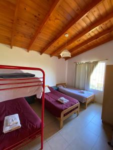 Cette chambre comprend 2 lits superposés et un plafond en bois. dans l'établissement Cabañas Los Pioneros, à Tandil