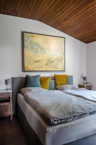 a bedroom with two beds and a painting on the wall at Eifel Cottage Biersdorf am See in Biersdorf