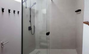 a shower with a glass door in a bathroom at Eifel Cottage Biersdorf am See in Biersdorf