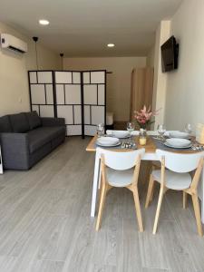 a living room with a table and chairs and a couch at APARTAMENTOS PLAYA VALENCIA in Valencia