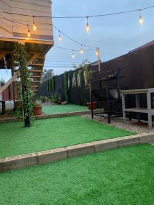 a backyard with green grass and lights on it at La Quebrada de Pinomar in El Quisco