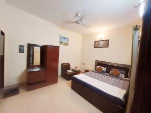Schlafzimmer mit einem Bett und einem Spiegel in der Unterkunft Embassy inn Guest House Hyderabad in Hyderabad