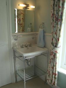a bathroom with a sink and a mirror at Stoneborough House B&B in Budleigh Salterton