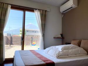 una camera con un letto e una grande finestra di 宝栄villas house A棟B棟 a Fujikawaguchiko