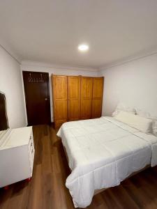 1 dormitorio con 2 camas y armarios de madera en Apartamento Las Perseidas, en Zaragoza
