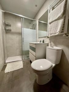 y baño blanco con aseo y ducha. en Apartamento Las Perseidas, en Zaragoza