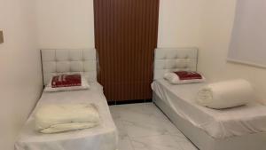 two beds sitting next to each other in a room at شاليه سما بارك in As Sayl aş Şaghīr