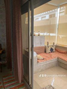 um quarto com uma cama com uma parede de vidro em Sidi rahel em Casablanca