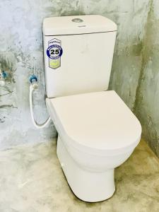 a white toilet with a sticker on it in a bathroom at LIFE OF COCO in Galge