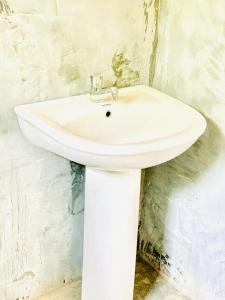 lavabo blanco en la esquina de un baño en LIFE OF COCO, en Galge
