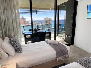 a bedroom with a bed and a view of the city at Oracle 28th floor Tower 2 Ocean views! - GC Getaways in Gold Coast