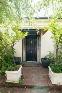 una puerta delantera de una casa con dos árboles en Parkview Cottage - Antique Elegance, en Orange