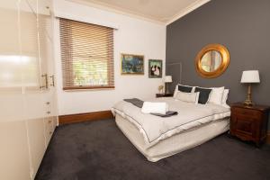 una camera con un grande letto e uno specchio di Parkview Cottage - Antique Elegance a Orange