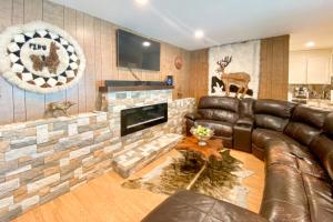 a living room with a leather couch and a fireplace at Clearlake Charmer in Clearlake Oaks