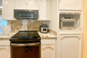 a kitchen with white cabinets and a stove top oven at Clearlake Charmer in Clearlake Oaks