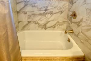 a white bath tub with a marble shower curtain at Clearlake Charmer in Clearlake Oaks