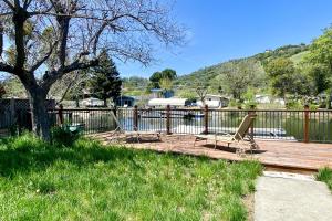 a wooden deck with a tree and a swing at Clearlake Charmer in Clearlake Oaks