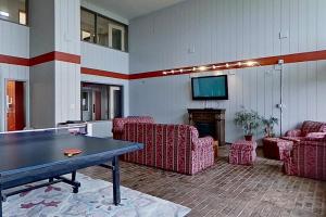 uma sala de estar com mesa de pingue-pongue e cadeiras em Cedar Lodge Condo, Unit 205 em Laconia