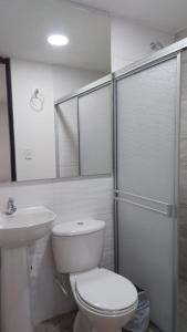 La salle de bains blanche est pourvue de toilettes et d'un lavabo. dans l'établissement Apto 202, à Cúcuta
