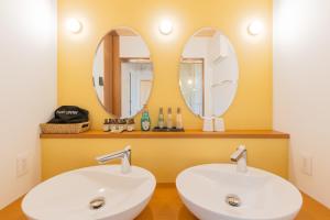 two sinks in a bathroom with two mirrors at AWAUMI　富士・河口湖リゾート in Fujikawaguchiko