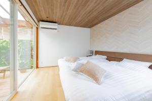 1 cama blanca grande en una habitación con ventana en AWAUMI　富士・河口湖リゾート, en Fujikawaguchiko