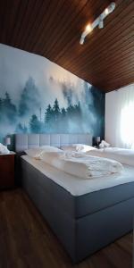 Schlafzimmer mit einem Bett mit Wandgemälde in der Unterkunft Ferienhaus Eifelurlaub in Biersdorf