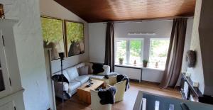 ein Wohnzimmer mit einem Sofa und einem Tisch in der Unterkunft Ferienhaus Eifelurlaub in Biersdorf