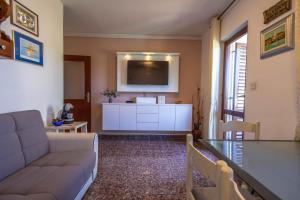 a living room with a couch and a flat screen tv at Apartments by the sea Podstrana, Split - 15963 in Podstrana