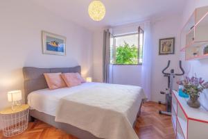 a bedroom with a bed and a window at Apartments by the sea Podstrana, Split - 15963 in Podstrana