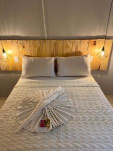 ein weißes Bett mit einem Korb darüber in der Unterkunft Pituba Ville - Ap 1 - 2 Quartos in Itacaré