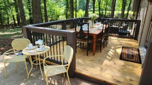 una terraza de madera con mesa y sillas. en Wolf Creek Lodge en Atlanta