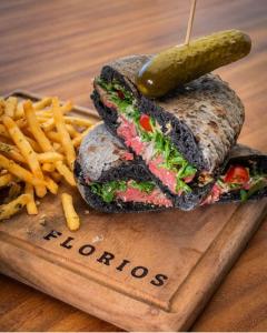 a sandwich with a pickle and french fries on a cutting board at Clandestino Hotel Pila Seca in San Miguel de Allende +16 photos