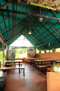 a restaurant with wooden tables and green ceilings at Agronest Farm & Resort By Teal Luxury Stay in Wayanad