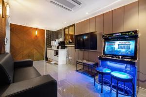 a living room with a television and a couch and stool at Pohang A1Hotel Haedo in Pohang +15 photos