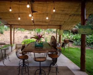 uma mesa de madeira e cadeiras sob uma pérgola em Vila ACONCHEGO AZUL 2 em Aracê