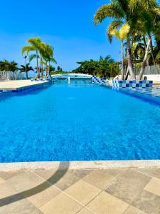 einen großen blauen Pool mit Palmen in der Unterkunft Apartamento nuevo con vista al mar in Coveñas