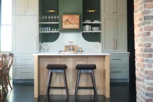 a kitchen with two stools at a kitchen island at The Juliette - Luxury Historic Residence in Charleston