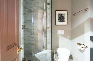 a bathroom with a glass shower with a toilet at The Juliette - Luxury Historic Residence in Charleston