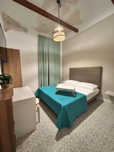 ein Schlafzimmer mit einem Bett mit einer blauen Decke in der Unterkunft Casa la cava in Taranto